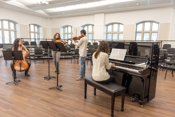 Four music students practicing together in a classroom space in O Neill Hall